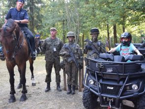 Na zdjęciu dziecko wraz z drużyną terytorialsów oraz policjantem konno