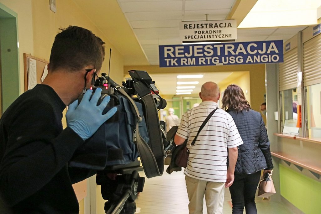 Na zdjęciu kamerzysta stacji TVP3 Poznań nagrywający ujęcie w korytarzu szpitala.