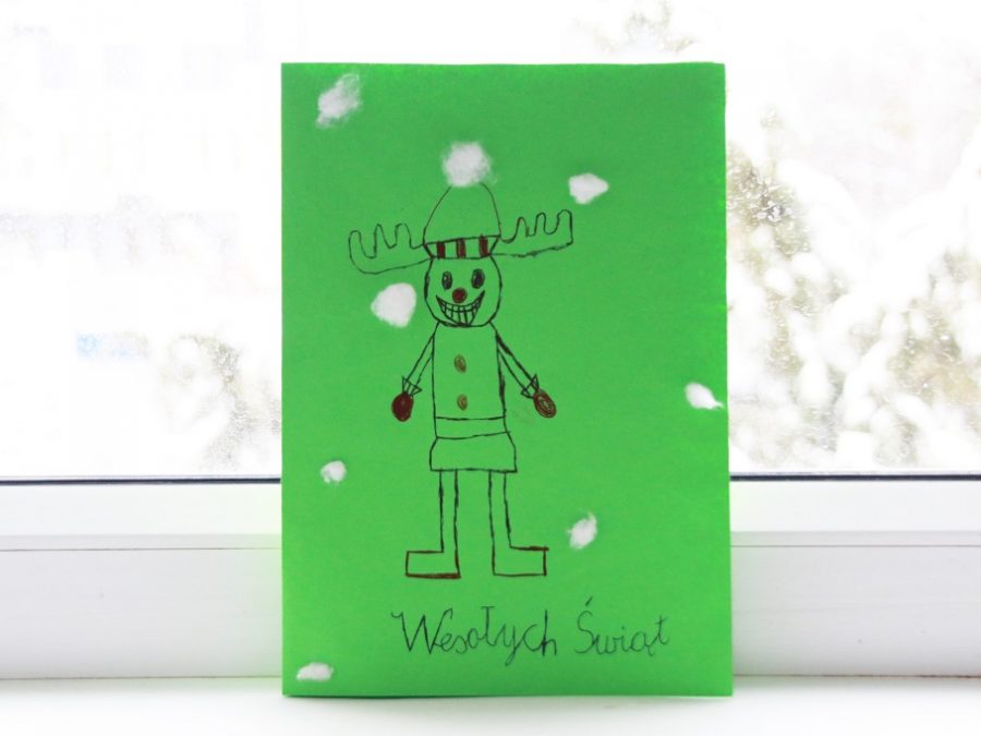 Zdjęcie przedstawia zielną kartkę z reniferem oraz napisem: Wesołych Świąt