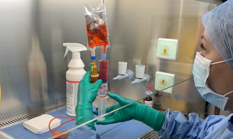 Zdjęcie przedstawia laboranta podczas sporządzania leków przeciwnowotworowych