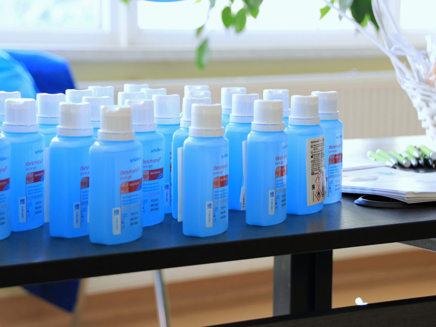 Zdjęcie przedstawia żele do dezynfekcji rąk w niebieskich butelkach